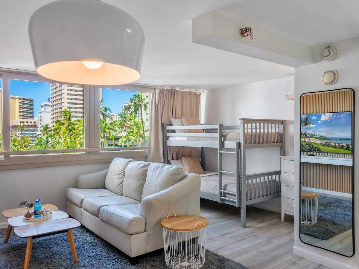 Living room with bunk beds, sleeper sofa, and corner windows