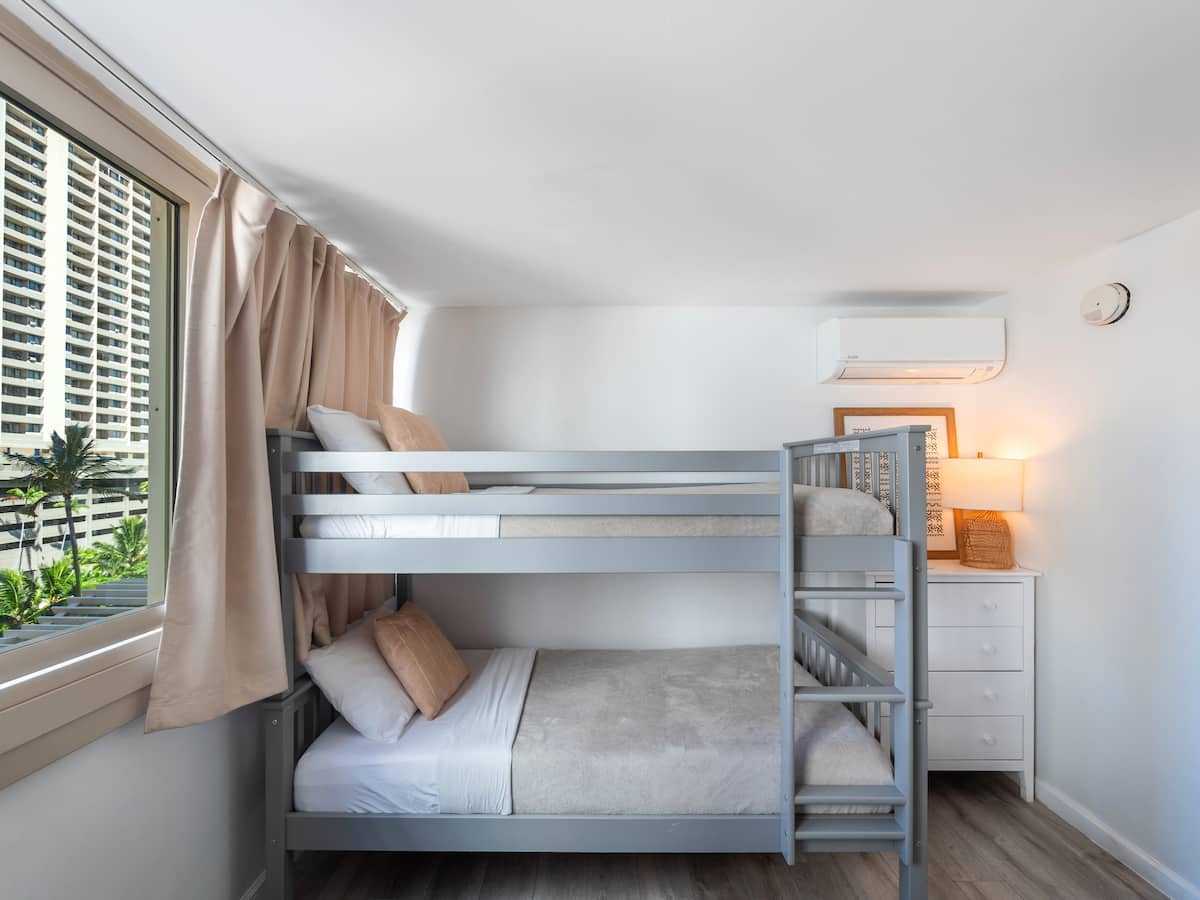 Two bunk beds beside the window in the bunk nook