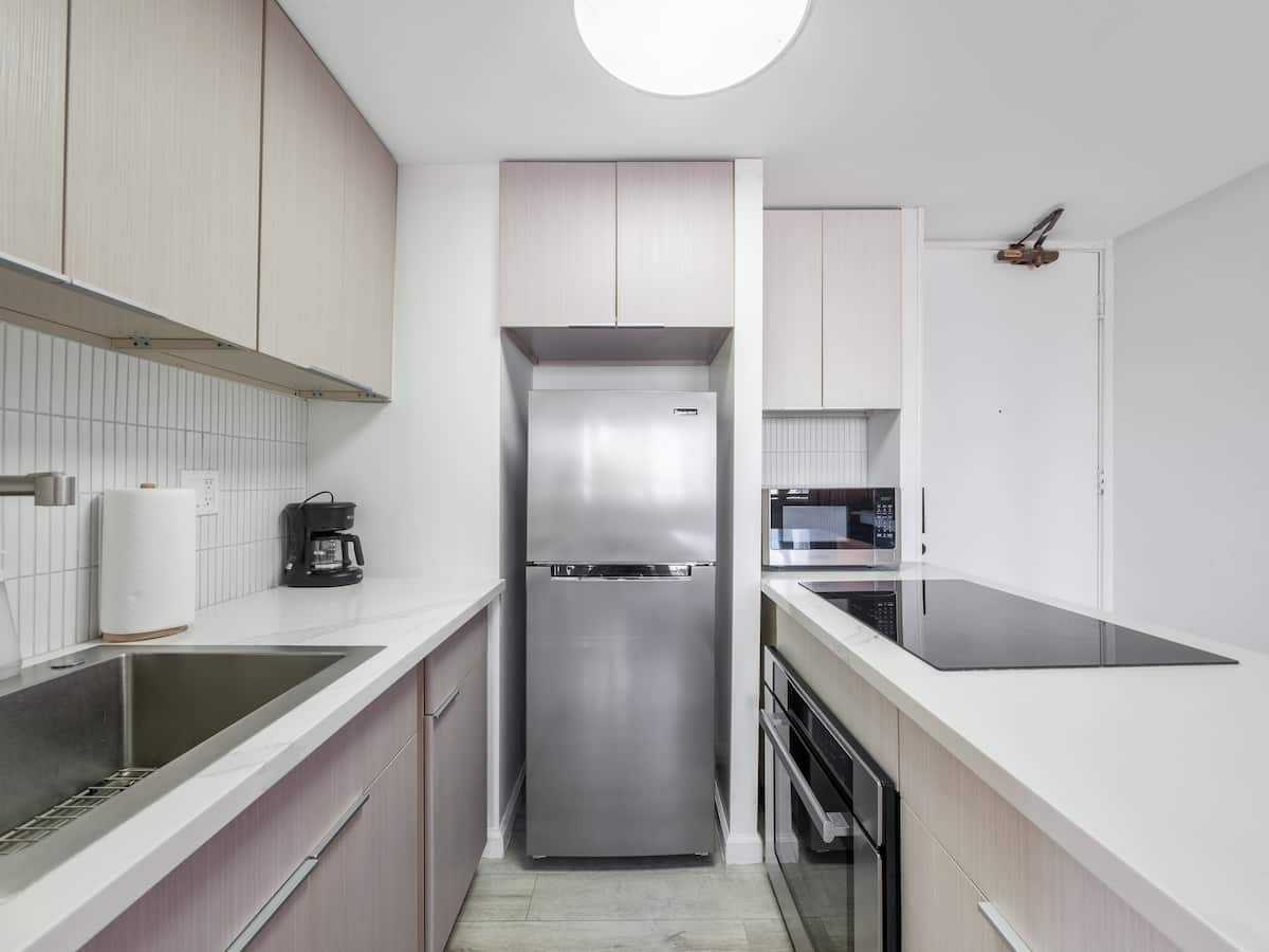 Galley kitchen with refrigerator, oven, and counter
