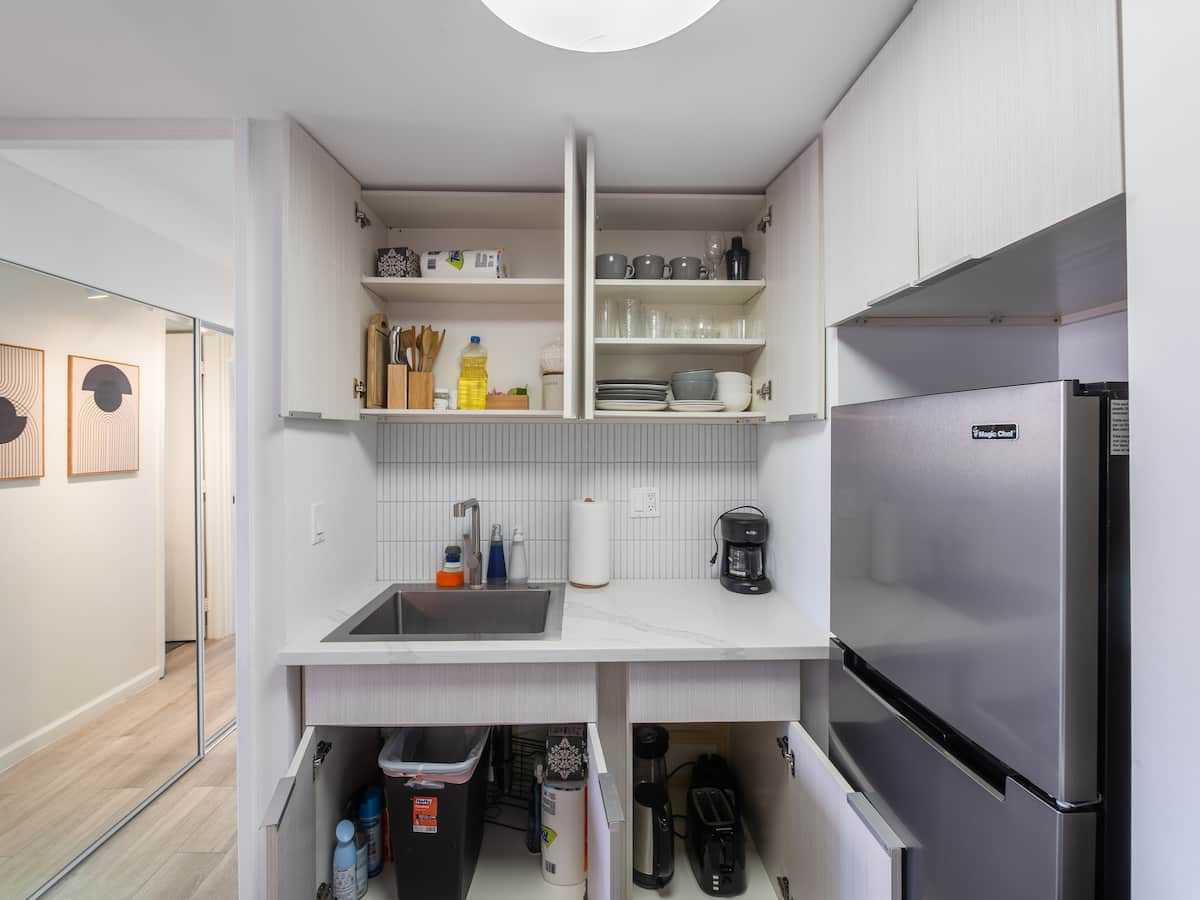 Open pantry cupboards beside the refrigerator