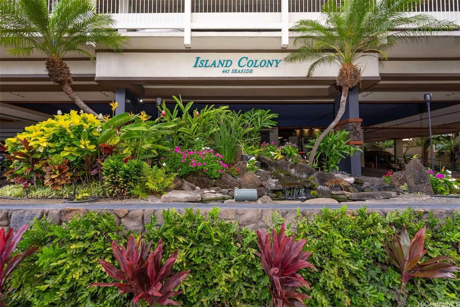 Island Colony entrance sign above tropical landscaping