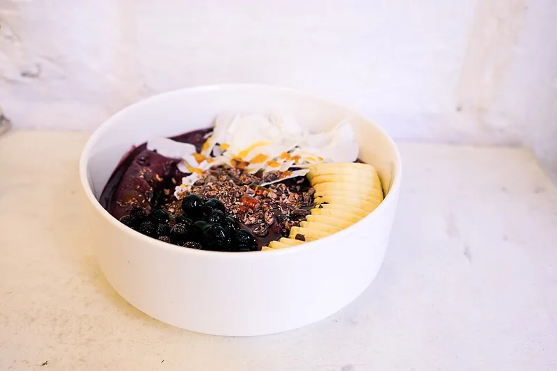 An açaí bowl topped with banana, blueberries, coconut and granola.