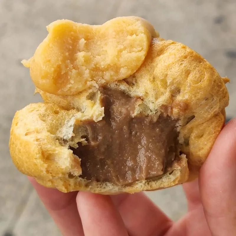 A Liliha Bakery Coco Puff opened to show the chocolate filling.